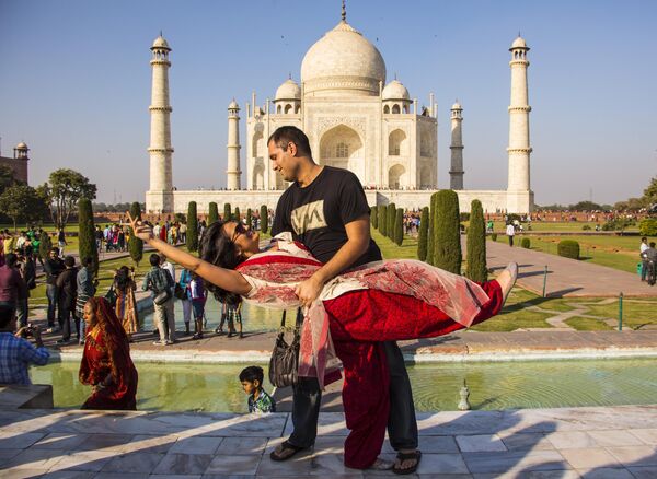 هنود وسياح من جميع أنحاء العالم يلتقطون صورا أمام معلم تاج محل السياحي الشهير في الهند. - سبوتنيك عربي