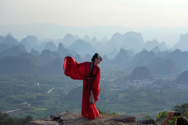 سائحة ترقص أمام الجبال والأنهار في منطقة يانجميلينغ (المعروفة باسم ألف ميل من الجبال والأنهار)، في مقاطعة يانغشو، الصين. - سبوتنيك عربي