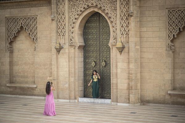 فتيات يلتقطن صورا تذكارية بجوار بوابة صومعة حسان، أحد مواقع التراث العالمي لليونسكو في الرباط، المغرب. - سبوتنيك عربي