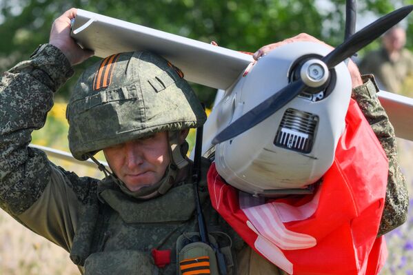 جندي روسي يحمل طائرة الاستطلاع المسيرة الروسية "أورلان-10" - سبوتنيك عربي