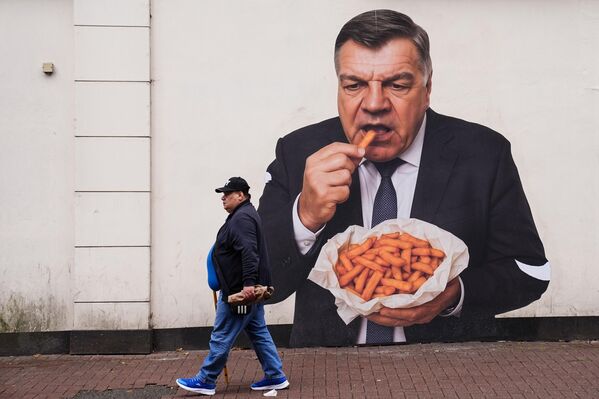 لوحة جدارية لمدرب منتخب إنجلترا السابق سام ألارديس، وهو يأكل أصابع البطاطا، معروضة في شارع "يونيون" وسط مدينة دادلي - سبوتنيك عربي