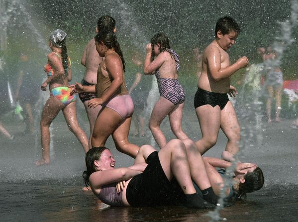 سكان يستحمون في نافورة في حديقة الذكرى المئوية الثالثة لتأسيس مدينة سانت بطرسبورغ، روسيا. - سبوتنيك عربي