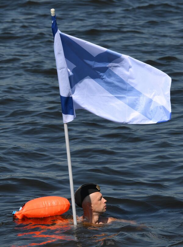 اتحاد السباحة الشتوية يسبح حاملا الأعلام في مياه محطة النهر الشمالية خلال الاحتفال بيوم البحرية. - سبوتنيك عربي