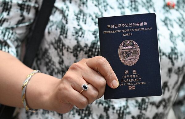مسافر يحمل جواز سفر كوريا الديمقراطية الشعبية في مطار "شيريميتيفو" الدولي، قبل أن تقلع أول رحلة جوية مباشرة من موسكو إلى بيونغ يانغ في 27 يوليو/تموز. - سبوتنيك عربي