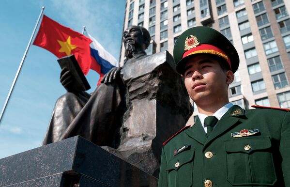 جندي روسي يقف بجانب تمثال الرئيس الأول لفيتنام الشمالية، هو تشي منه، في مدينة سانت بطرسبورغ. - سبوتنيك عربي