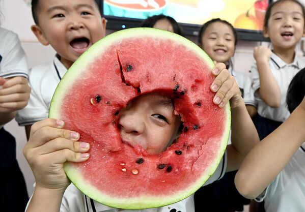 أطفال يتناولون البطيخ في روضة أطفال في هاندان، مقاطعة خبي شمال الصين. - سبوتنيك عربي