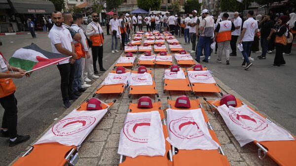 جنازة رمزية لـ 48 من أعضاء جمعية الهلال الأحمر الفلسطيني الذين فقدوا أرواحهم أثناء تأدية واجبهم الإنساني خلال الحرب الإسرائيلية في غزة 12 مايو 2025  - سبوتنيك عربي