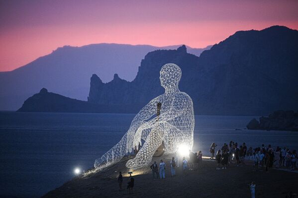 زوار بالقرب من هيكل فني في مكان إقامة مهرجان الشباب العاملين في الثقافة والفنون "تافريدا. آرت-2025"، في خليج "كابسيل" بجمهورية القرم الروسية - سبوتنيك عربي