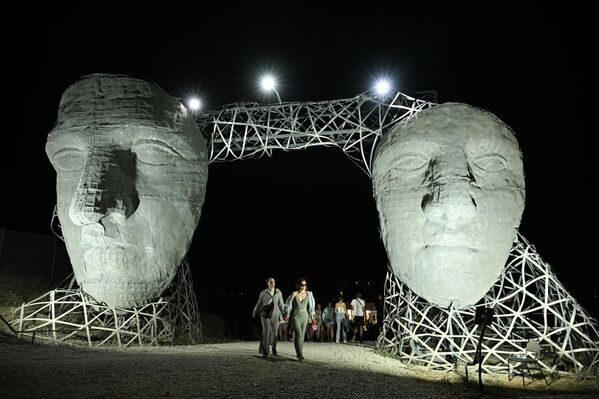 زوار بالقرب من هيكل فني في موقع مهرجان الشباب العاملين في الثقافة والفنون "تافريدا. آرت-2025"، في خليج "كابسيل" بجمهورية القرم الروسية - سبوتنيك عربي