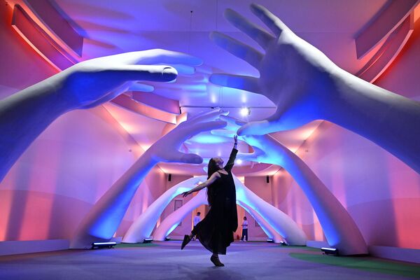 فتاة تؤدي رقصة أمام إحدى البوابات المؤدية إلى مركز تنظيم مهرجان "أرض المستقبل.. موسكو 2030" - سبوتنيك عربي