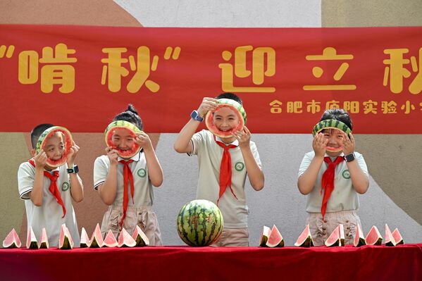 طلاب مدرسة ابتدائية يشاركون في مسابقة أكل البطيخ احتفالًا بقدوم "لي تشيو"، المعروف ببداية الخريف، في مقاطعة آنهوي، الصين. - سبوتنيك عربي