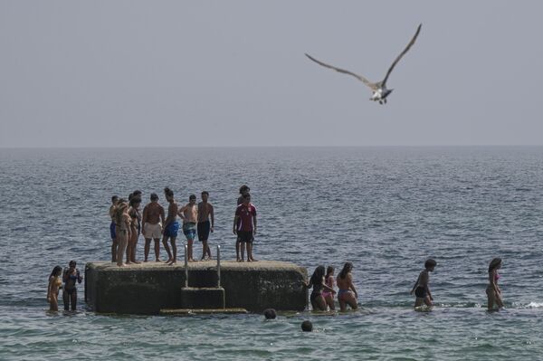سياح يستجمون على شاطئ برايا دو تاماريز في إستوريل، البرتغال. - سبوتنيك عربي