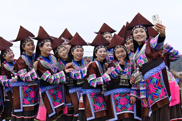 نساء من قومية مياو يلتقطن صورة سيلفي خلال احتفال بمهرجان "تياوهوا" في 5 فبراير 2025 في منطقة غويآن الجديدة بمقاطعة قويتشو الصينية. - سبوتنيك عربي