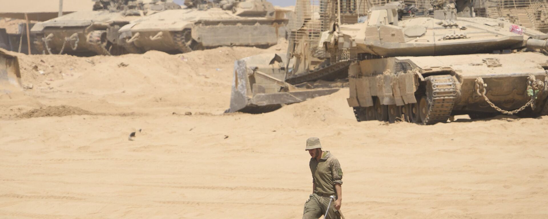 جندي إسرائيلي يعمل على دبابة في منطقة  على الحدود مع قطاع غزة - سبوتنيك عربي, 1920, 08.10.2025