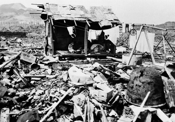 عائلة يابانية تتناول الأرز في كوخ بدائي بنوه من حطام منزلهم المدمر في ناغازاكي، 14 سبتمبر/ أيلول 1945 - سبوتنيك عربي