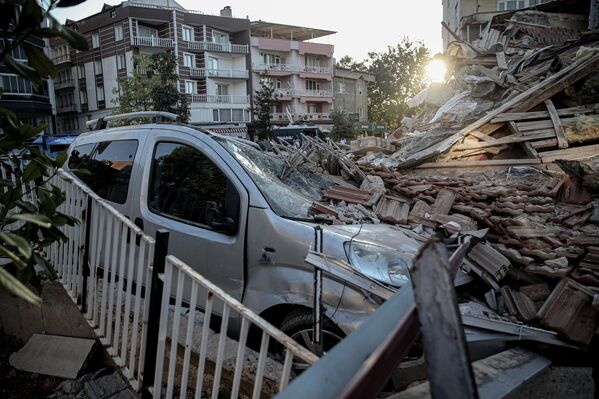 تُظهر الصورة مبانٍ مُدمّرة وسيارة، بينما تستمر جهود البحث والإنقاذ في مبنى منهار من 3 طوابق، بعد وقوع زلزال بقوة 6.1 درجات على مقياس ريختر في منطقة سينديرجي في باليكسير، تركيا، في 11 أغسطس 2025 - سبوتنيك عربي