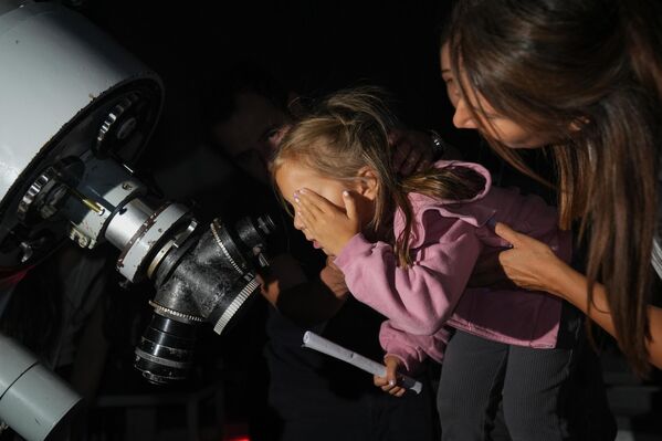 تركيا... صورة ملتقطة لفتاة تنظر إلى زخة شهب من خلال تلسكوب بينما يتجمع عشاق علم الفلك في مرصد كريكن بجامعة أنقرة. - سبوتنيك عربي