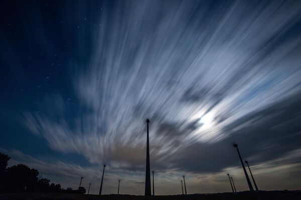 صورة ملتقطة للسماء في ولاية مكلنبورغ فوربومرن الألمانية، تظهر غيوما تمر فوق مزرعة رياح في سماء الليل، مما يحول دون رصد سيل شهب البرشاويات. - سبوتنيك عربي