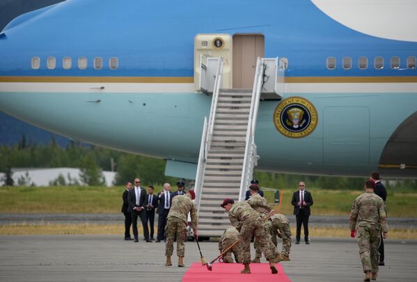 أفراد من الجيش الأمريكي يضعون السجادة الحمراء أمام طائرة الرئيس الأمريكي دونالد ترامب - سبوتنيك عربي