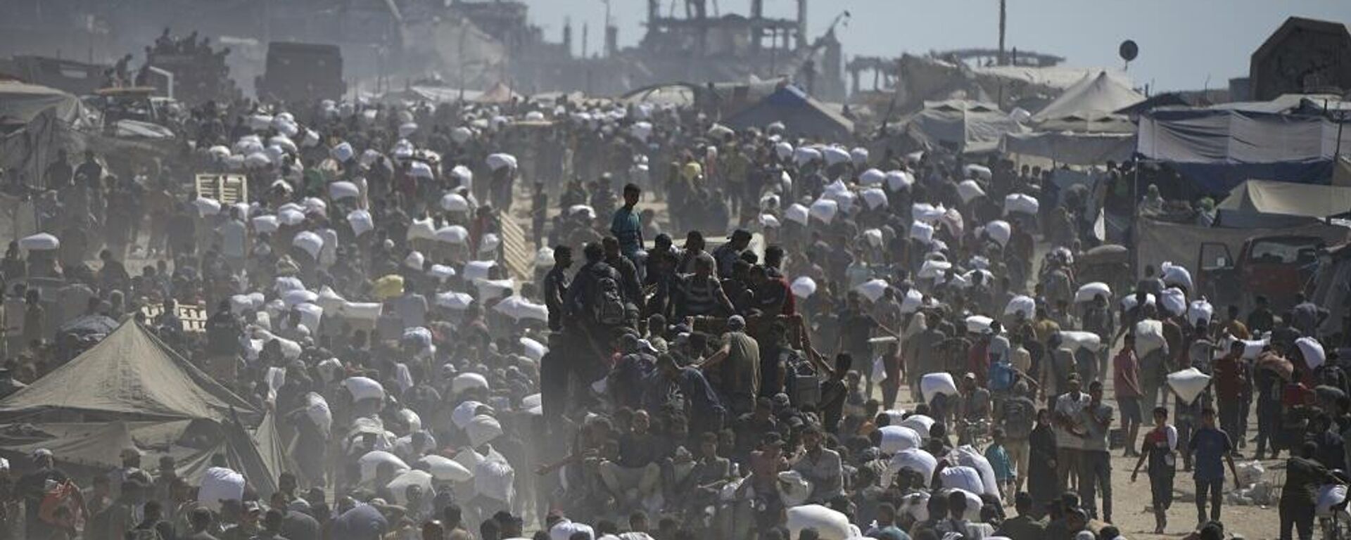 فلسطينيون يحملون أكياس الدقيق المأخوذة من قافلة مساعدات إنسانية في طريقها إلى مدينة غزة، على مشارف بيت لاهيا، شمال قطاع غزة، 1 أغسطس/ آب 2025 - سبوتنيك عربي, 1920, 16.10.2025