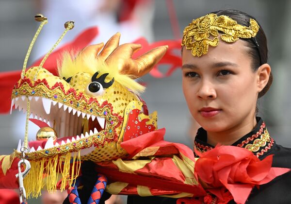 فتاة تقدم أحد العروض خلال افتتاحية مسابقة &quot;قوارب التنين&quot; الصينية، في بحيرة &quot;نيجني كابان&quot; في مدينة قازان الروسية - سبوتنيك عربي