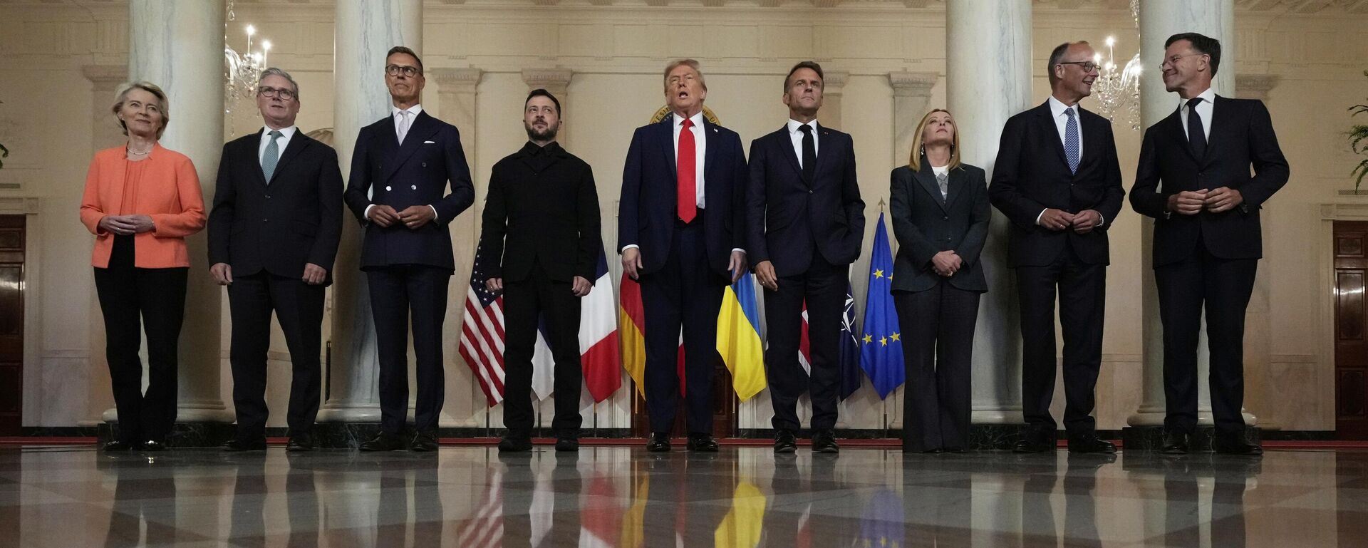 European Commission President Ursula von der Leyen, from left, British Prime Minister Keir Starmer, Finland's President Alexander Stubb, Ukraine's Volodymyr Zelensky, President Donald Trump, France's President Emmanuel Macron, Italy's Prime Minister Giorgia Meloni, Germany's Chancellor Friedrich Merz and NATO Secretary General Mark Rutte pose for a group photo in the Grand Foyer of the White House, Monday, Aug. 18, 2025, in Washington.  - سبوتنيك عربي, 1920, 21.08.2025