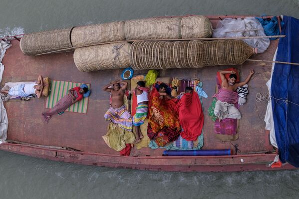 تجار ينامون على متن قارب متجه إلى سوق "سادارغات" في دكا، بنغلاديش - سبوتنيك عربي