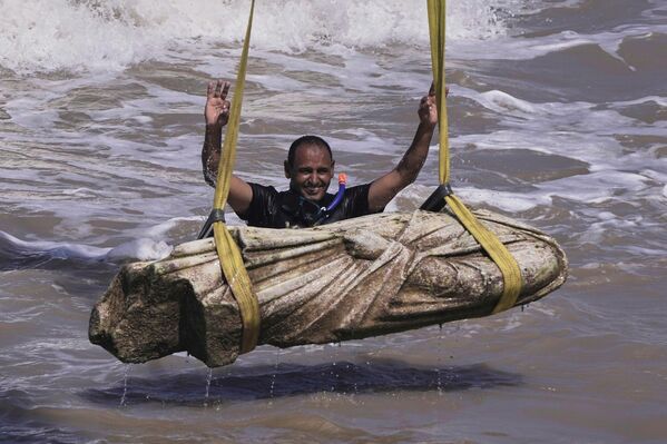 غواص يحتفل بعد انتشال إحدى الآثار القديمة من المياه في خليج "أبو قير" بمدينة الإسكندرية، مصر - سبوتنيك عربي