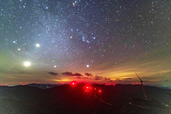النجوم تتلألأ بينما يلوّن ضوء الصباح سماء مزرعة رياح جبل دابانغ في ليلة صافية في الصين. - سبوتنيك عربي
