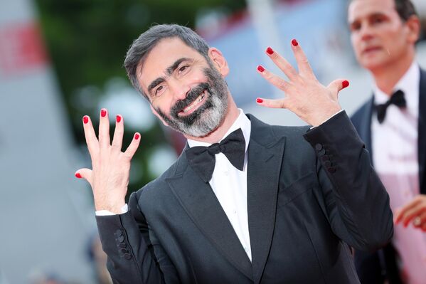 يوري أنكاراني، عضو لجنة تحكيم مهرجان البندقية السينمائي الدولي الثاني والثمانين، يقلد الفتيات، بوضعه طلاء الأظافر على أصابعه. - سبوتنيك عربي