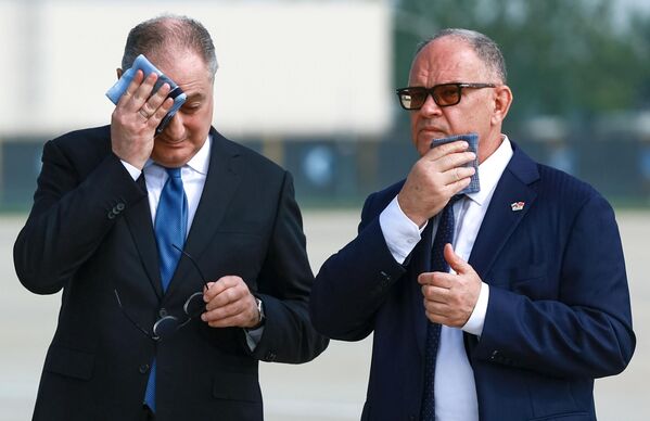 السفير الروسي لدى الصين إيغور مورغولوف والممثل التجاري الروسي لدى الصين أليكسي داخنوفسكي (يمين) يلتقيان الرئيس الروسي، فلاديمير بوتين، في مطار بينهاي في تيانجين في الصين. - سبوتنيك عربي