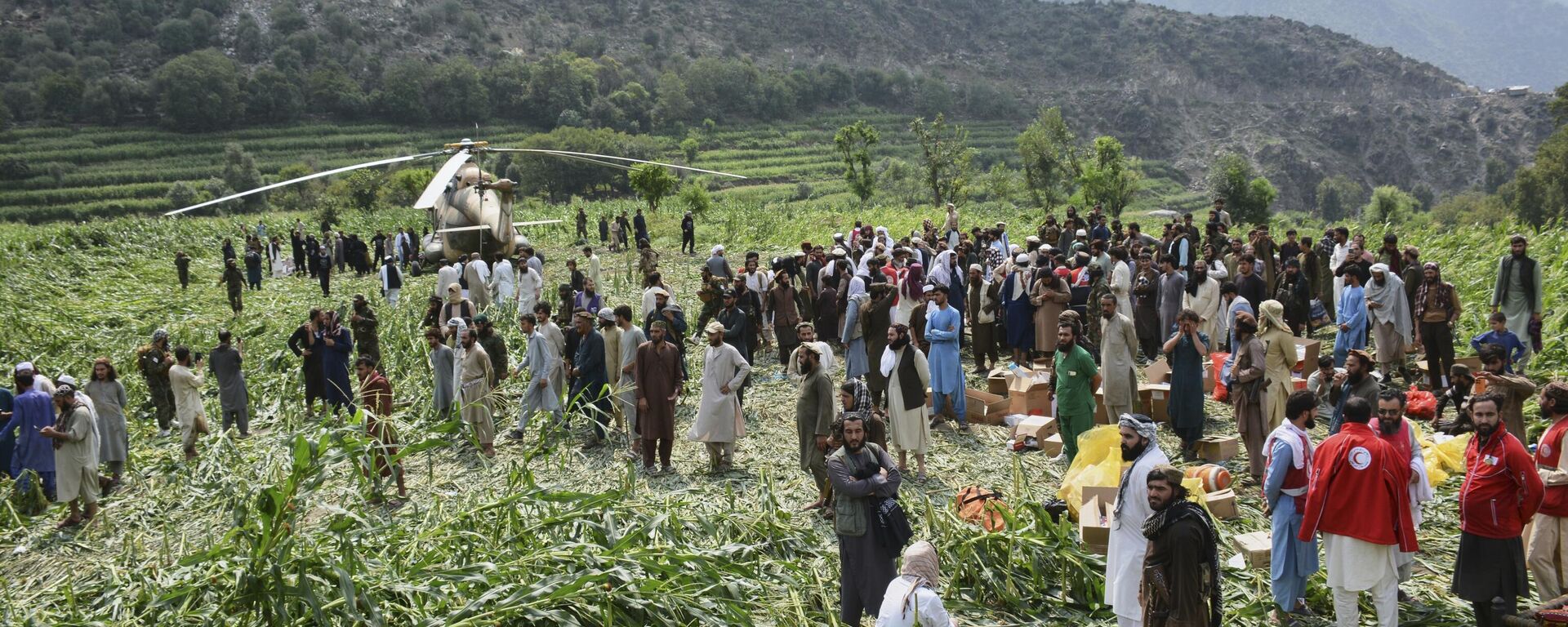 يتجمع السكان المحليون حول مروحية عسكرية هبطت لإجلاء الضحايا المصابين في زلزال أودى بحياة العديد من الأشخاص ودمر قرى في شرق أفغانستان، في مزار دارا، ولاية كونار، أفغانستان، يوم الاثنين 1 سبتمبر/أيلول 2025. - سبوتنيك عربي, 1920, 04.09.2025