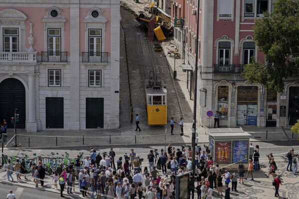 لقطة عامة تظهر تجمهر الناس حول عربة &quot;ترام&quot; سياحية خرجت عن مسارها وتحطمت في لشبونة. البرتغال. - سبوتنيك عربي