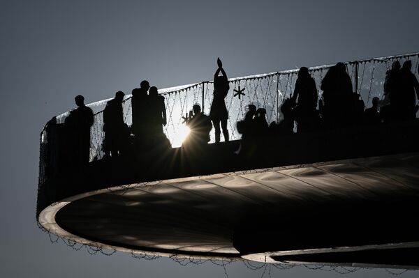 زوار يلتقطون الصور على الجسر العائم في حديقة "زاريادي" الطبيعية في موسكو. - سبوتنيك عربي