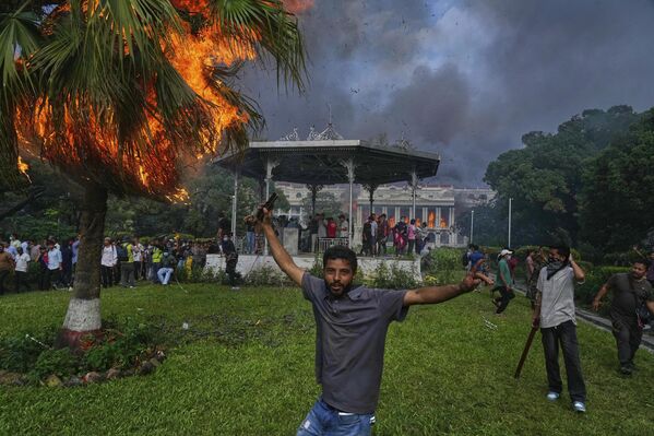 متظاهرون يحتفلون في سينغا دوربار، مقر الوزارات والمكاتب الحكومية النيبالية المختلفة، بعد إحراقه خلال احتجاج ضد حظر وسائل التواصل الاجتماعي والفساد في كاتماندو، نيبال. - سبوتنيك عربي