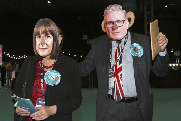 أعضاء حزب الإصلاح يرتدون أقنعة لرئيس الوزراء البريطاني كير ستارمر، ووزيرة الخزانة البريطانية راشيل ريفز، خلال المؤتمر السنوي لحزب الإصلاح في مركز المعارض الوطني في برمنغهام، إنجلترا. - سبوتنيك عربي