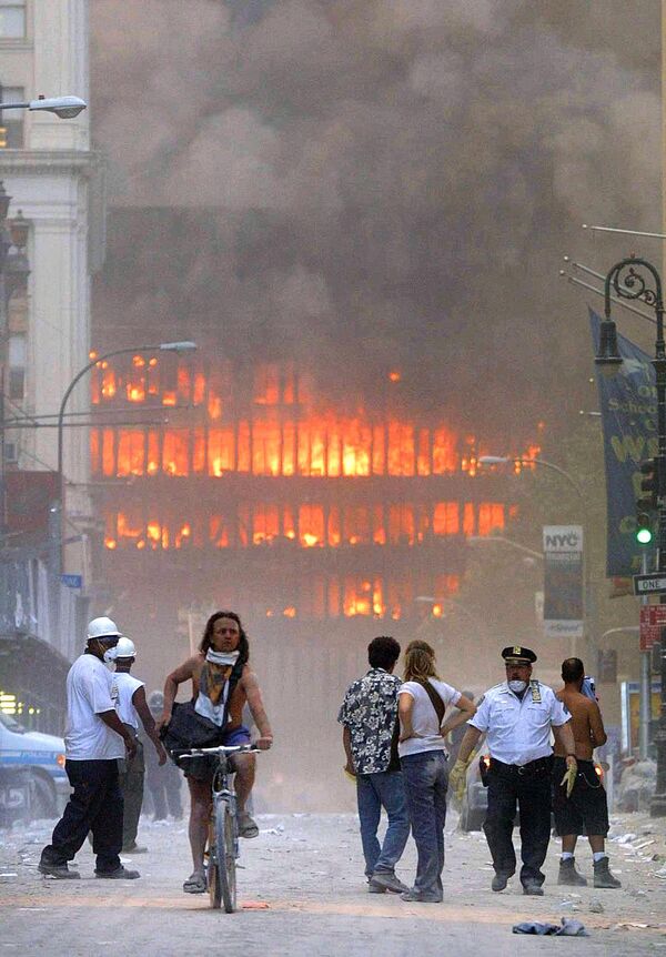 سكان مدينة نيويورك يسيرون في الشارع، بالمنطقة التي انهار فيها مبنى مركز التجارة العالمي، بعد اصطدام طائرتين بالبرجين التوأمين - سبوتنيك عربي