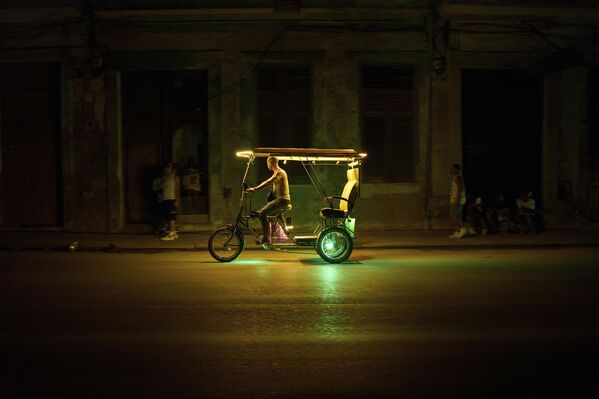 رجل يقود عربة ريكشا أثناء انقطاع التيار الكهربائي في هافانا. - سبوتنيك عربي