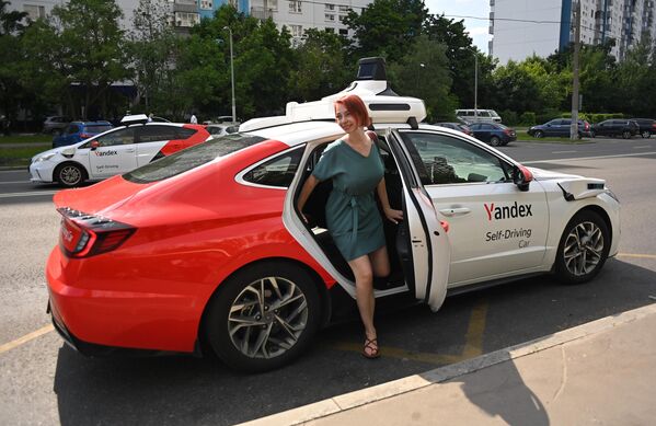 مستخدمة تطبيق "ياندكس غو" تخرج من سيارة أجرة ذاتية القيادة في موسكو، روسيا. - سبوتنيك عربي