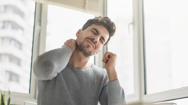 شاب يعاني من ألم في الرقبة في الصباح. - سبوتنيك عربي