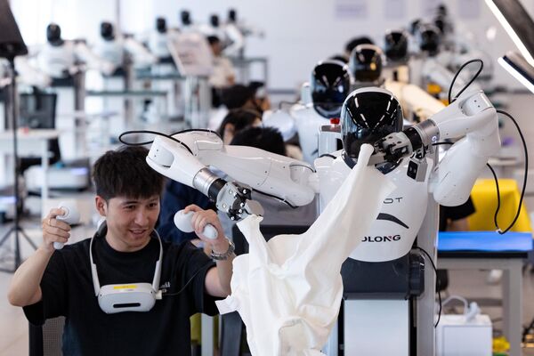 روبوتات بشرية تتبع الفنيين لتعلم مهارات العمل في مركز ابتكار روبوتات الذكاء الاصطناعي في مقاطعة تشجيانغ، الصين. - سبوتنيك عربي