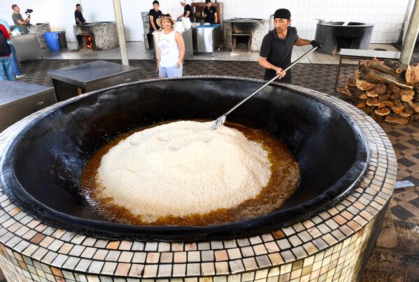 رجل يقوم بإعداد وجبة "البلوف" في مركز بيش قوزون  في طشقند. - سبوتنيك عربي