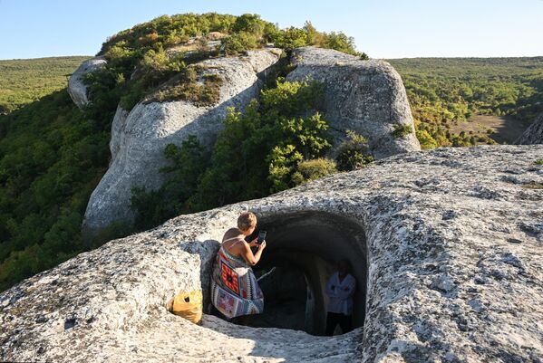سائحة تستكشف أحد الكهوف في مدينة "إسكي كيرمن" في شبه جزيرة القرم. - سبوتنيك عربي