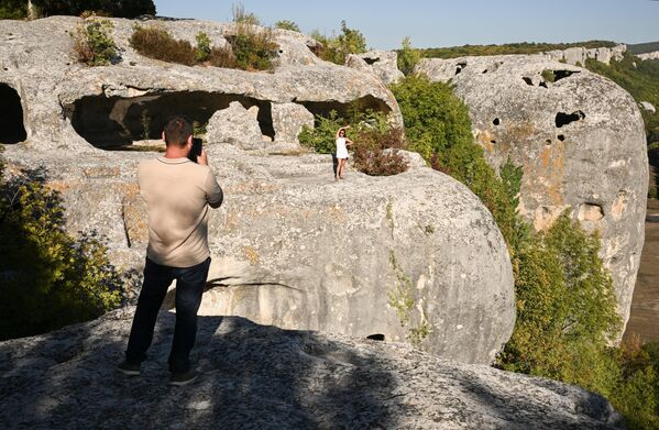 سياح يلتقطون صورا أمام مدخل أحد الكهوف في مدينة "إسكي كيرمن" في شبه جزيرة القرم. - سبوتنيك عربي