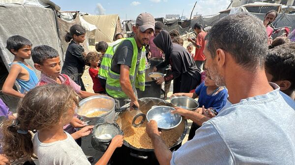 متطوعون يكافحون لتوزيع الطعام على النازحين في قطاع غزة في ظل استمرار المجاعة   - سبوتنيك عربي