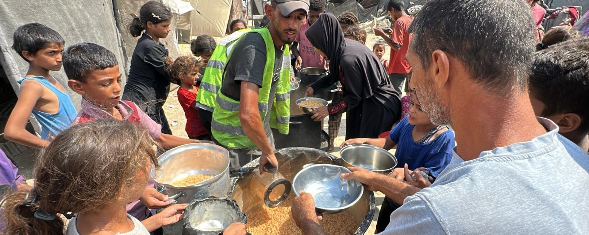 متطوعون يكافحون لتوزيع الطعام على النازحين في قطاع غزة في ظل استمرار المجاعة   - سبوتنيك عربي, 1920, 22.12.2025