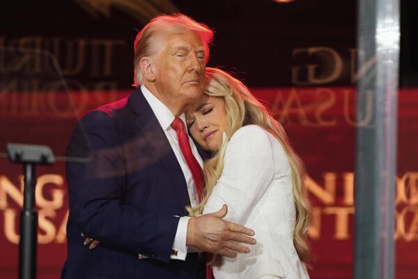 الرئيس الأمريكي دونالد ترامب، يعانق إريكا كيرك، بالقرب من النصب التذكاري لزوجها، الناشط المحافظ تشارلي كيرك، في ملعب ستيت فارم في أريزونا، الولايات المتحدة. - سبوتنيك عربي