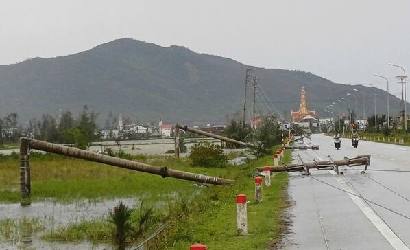 انهيار أعمدة الكهرباء على الطريق بسبب الإعصار الذي اجتاح  ثانه هوا، في  فيتنام.  - سبوتنيك عربي