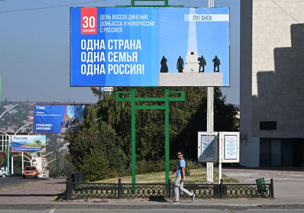 لوحة إعلانية في أحد شوارع لوغانسك في يوم إعادة توحيد الكيانات الجديدة مع روسيا. - سبوتنيك عربي
