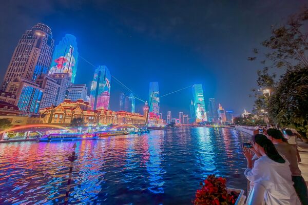 مباني مضائة على طول نهر هايخه، خلال عرض ضوئي احتفالًا بالذكرى السادسة والسبعين لتأسيس جمهورية الصين الشعبية. - سبوتنيك عربي